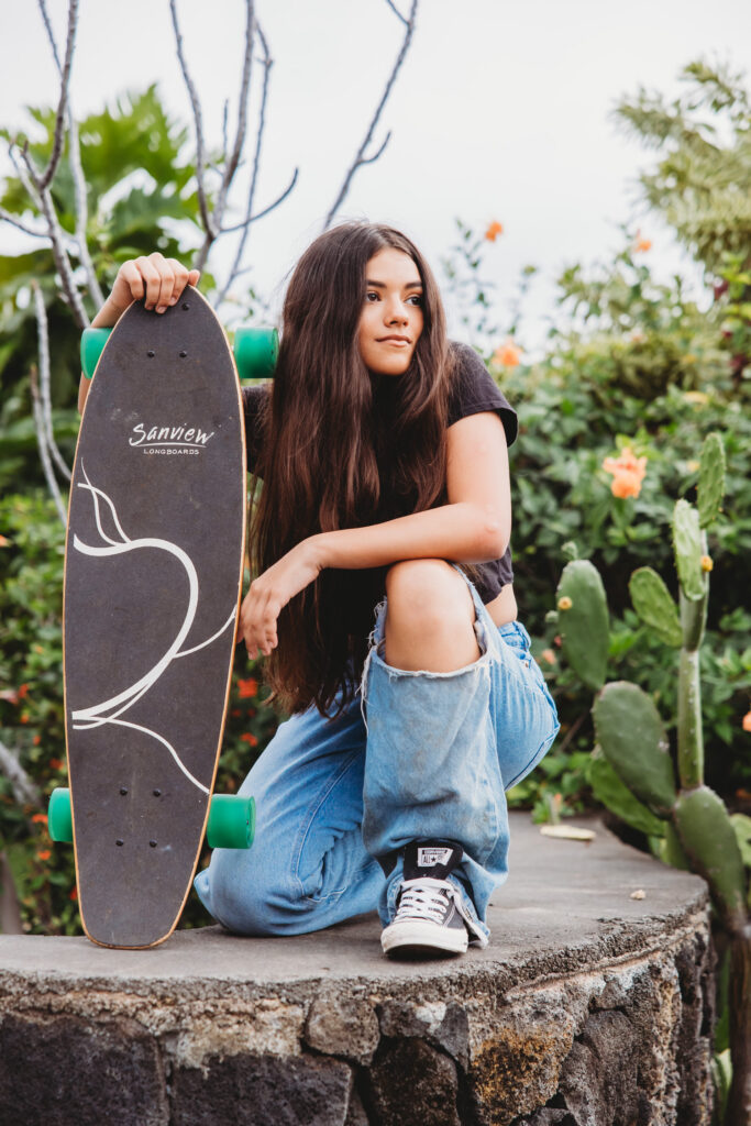 Hawaii - Destination Teen Photography Session. Girl with long hair on skate board looking stylish with ripped jeans and converse