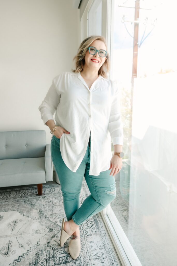woman in white button down shirt and denim jeans with red lipstick and blonde hair posing for her Sacramento Brand Photography session