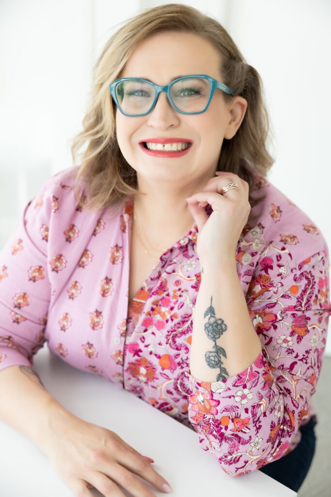 woman in pink paisley shirt with blue glasses, red lipstick and tattoos in Sacramento Brand photography session