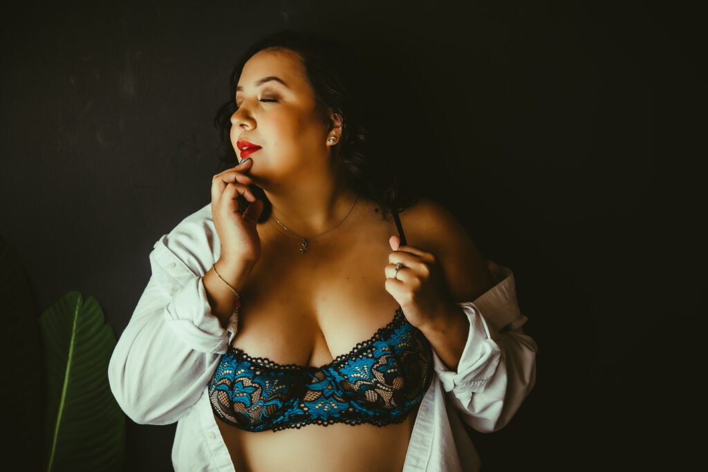 woman in mends white shirt with blue and black lace bra and red lipstick 