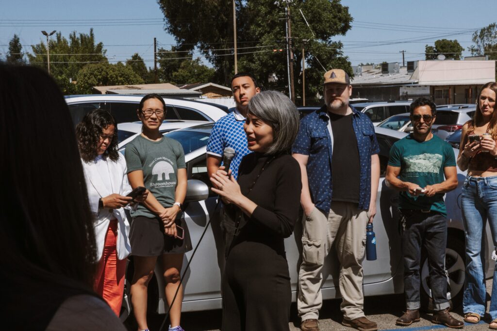 Business owners and community members gathered outside a Sacramento photography studio during a grand opening and ribbon-cutting celebration.